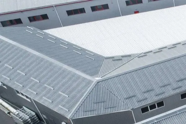 Aerial view of a gray standing seam metal roof on a large commercial building